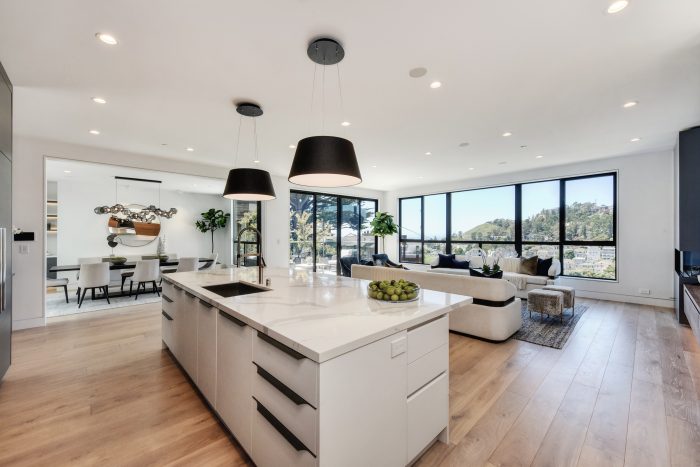 The expansive great room opens to an oversized patio for alfresco dining amid ocean views and twinkling hillside lights.