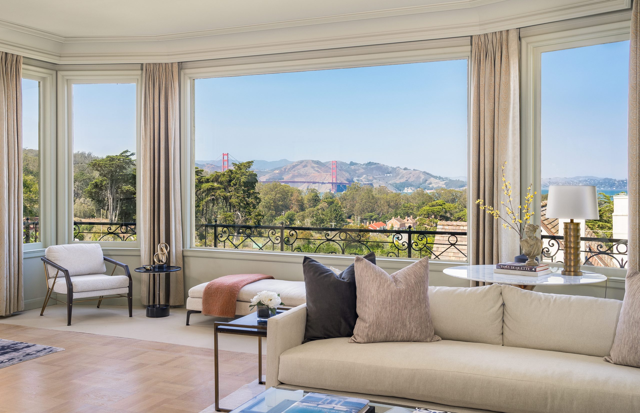A lavish wrought iron and glass front door opens to a captivating world of light-swept parquet floors
