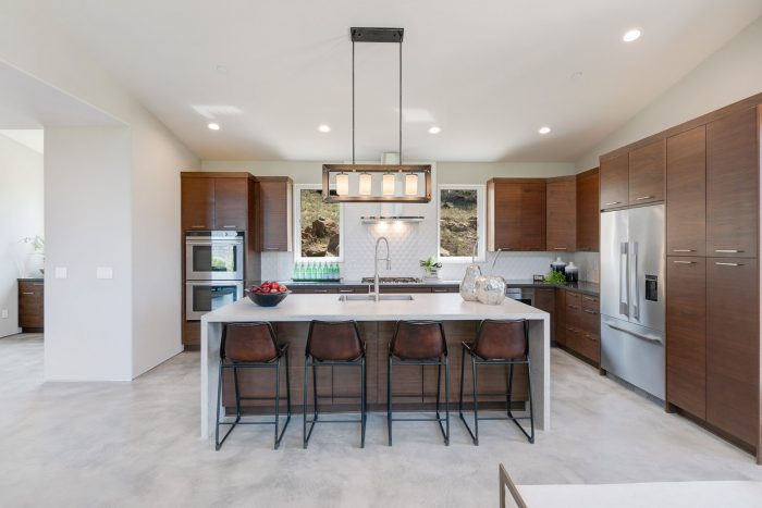 Long view of kitchen with high end appliances and cupboards.