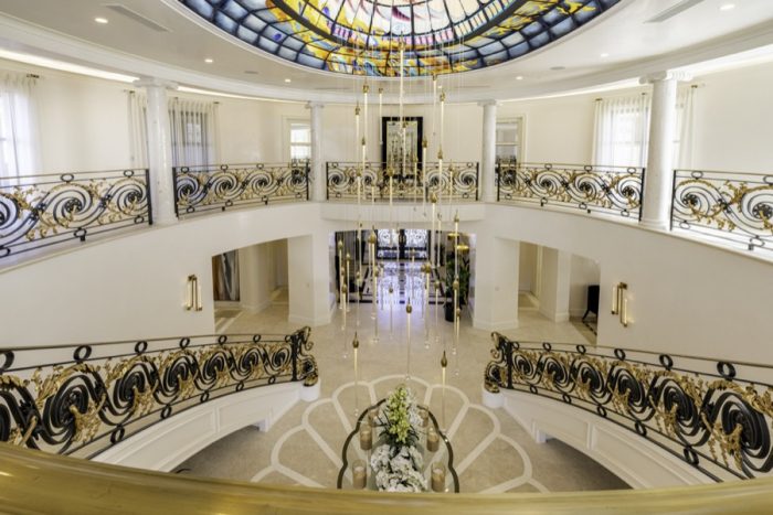 Foyer with ornate side railings and glass ceiling.