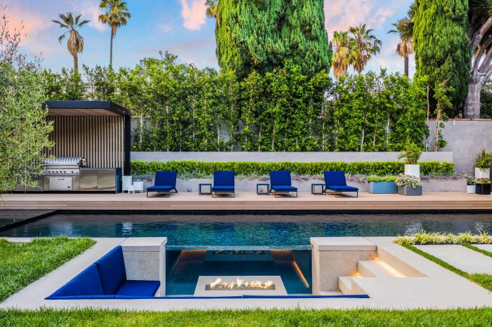The oversized backyard boasts a sparkling pool with a see-through glass wall.