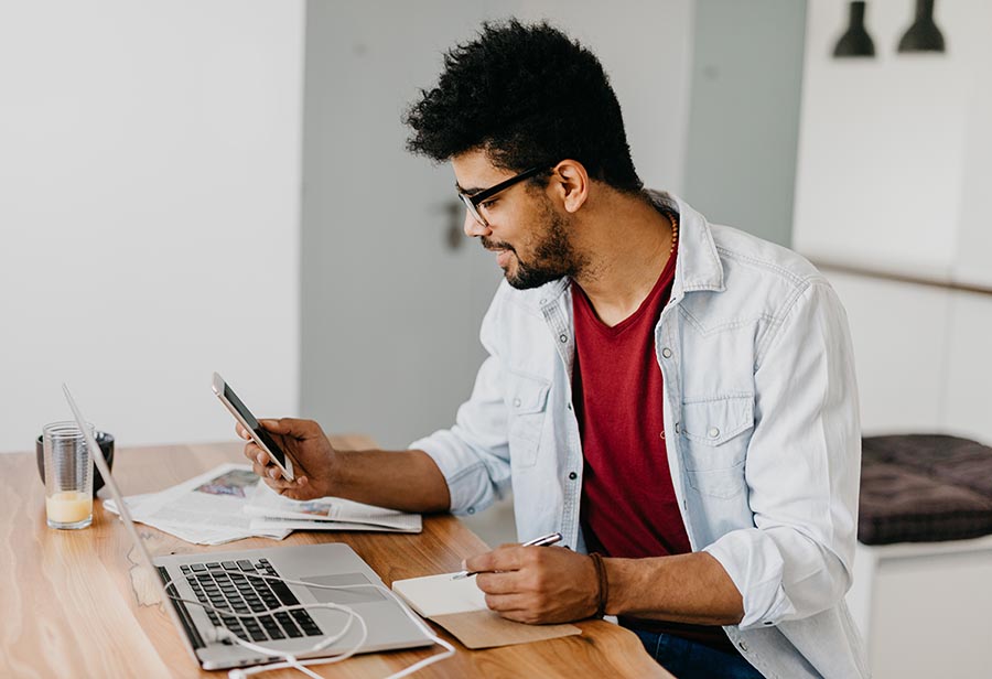 Man sitting at the desk and paying bills with his credit card online using laptop.