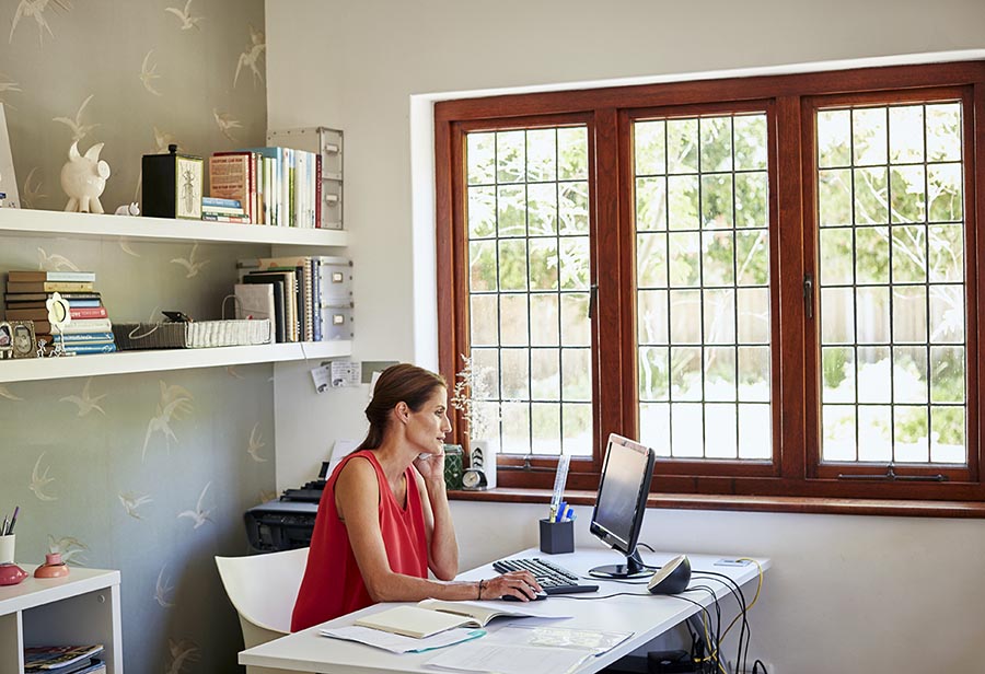Woman using computer and mobile phone at desk