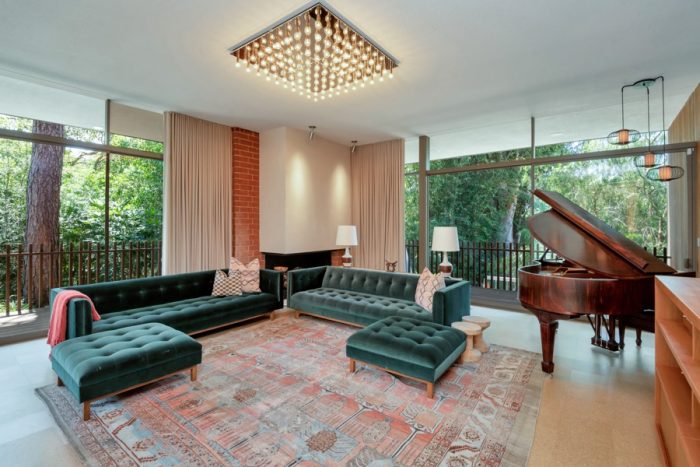 Compass living room with green sofas, and grand piano.