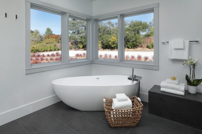 Stand alone tub surrounded by windows.