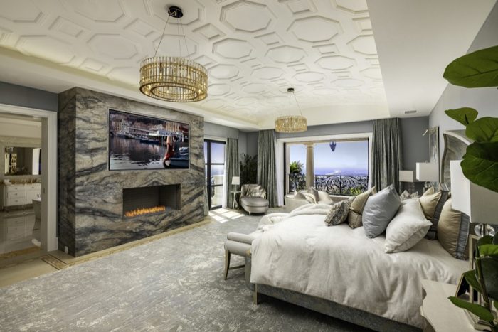 Mater suite with views of OC and a large screen above the fireplace.