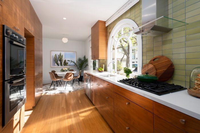 Tiled kitchen, wood floors and cabinets, Danish chairs.